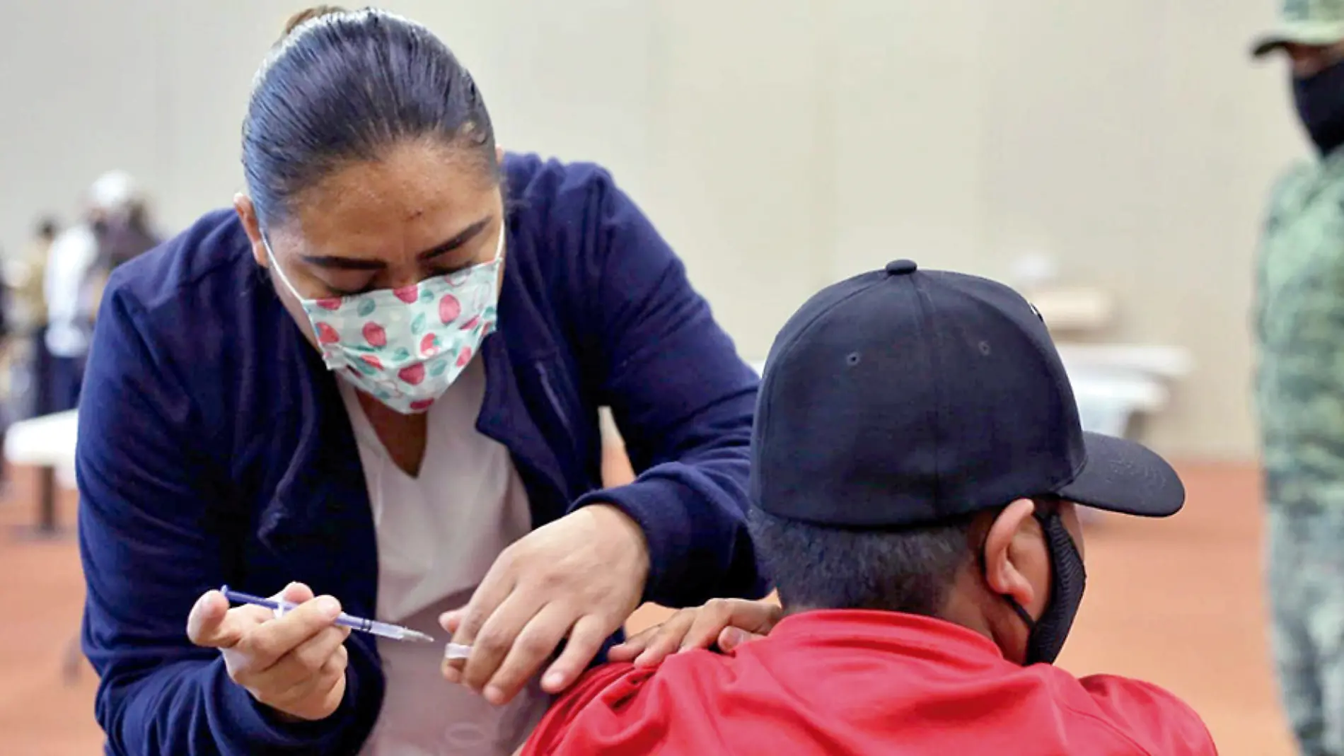 Enfermera aplica vacuna contra Covid-19 a un joven